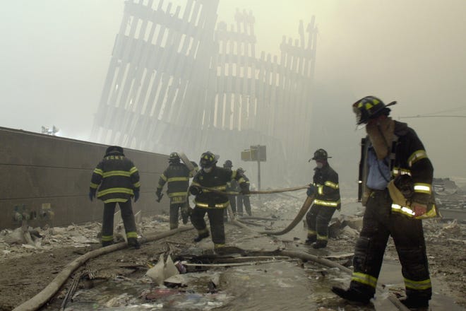 In this Sept. 11, 2001, file photo, firefighters work beneath the destroyed mullions, the vertical struts which once faced the outer walls of the World Trade Center towers, after a terrorist attack on the twin towers in New York. New research released on Friday, Sept. 6, 2019 suggests firefighters who arrived early or spent more time at the World Trade Center site after the 9/11 attacks seem to have a greater risk of developing heart problems than those who came later and stayed less. [AP Photo/Mark Lennihan]