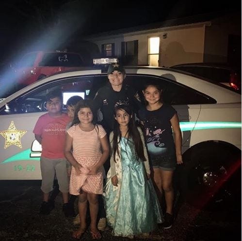 Okaloosa County Sheriff's Deputy Misty Piaget poses with children at a birthday party. [CONTRIBUTED PHOTO]