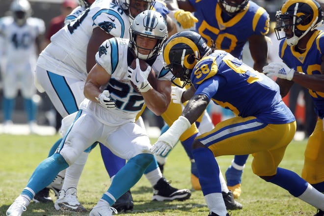 Carolina Panthers running back Christian McCaffrey (22) runs while Los Angeles Rams inside linebacker Cory Littleton (58) goes for the tackle during the second half Sunday in Charlotte, N.C. The Panthers play the Tampa Bay Bucs on Thursday night. [BRIAN BLANCO/THE ASSOCIATED PRESS]