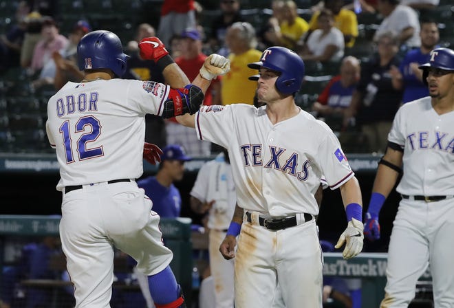 Texas Rangers' Rougned Odor (12) and Nick Solak celebrate Odor's three-run home run as Ronald Guzman, right rear, watches during the seventh inning of the team's baseball game against the Tampa Bay Rays in Arlington, Texas, Wednesday TONY GUTIERREZ/THE ASSOCIATED PRESS