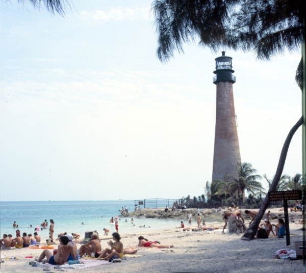 People enjoying a day at the beach by the Cape Florida lighthouse. April 1979. (State Archives of Florida)