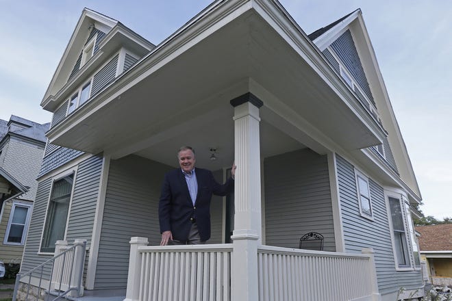 Paul Kevin Gees poses last month on the porch of the house he bought and renovated on North Sixth Street in Quincy, IIlinois. Gees said restoring the Victorian-era home has been a labor of love for him. [KATELYN METZGER/QUINCY HERALD-WHIG VIA AP]