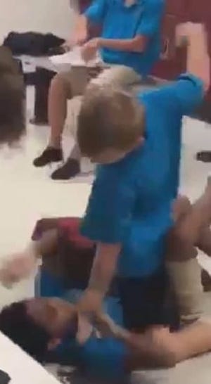 A still image from a fight in Blake Academy's locker room shows the accused instigator holding down a classmate by the throat and about to punch him. [VIDEO PROVIDED]