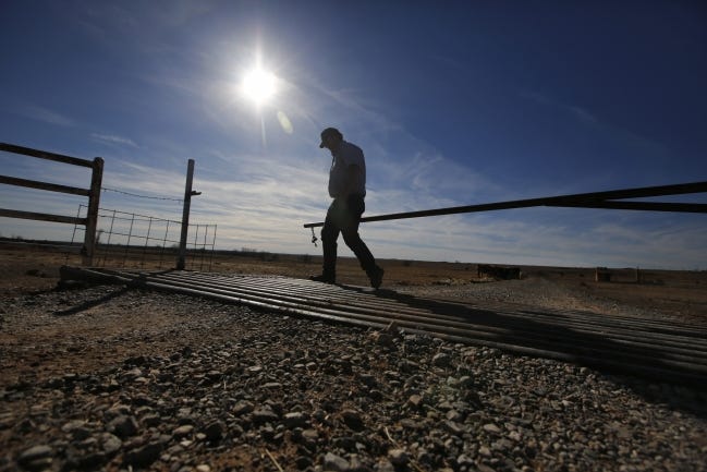 A cattle farmer in Canadian County shuts a gate during a drought in 2015. Oklahoma will likely see expanded severity in floods, droughts, wildfires, heavy rainfall and days of extreme heat as greenhouse gases produced by human activities increase global temperatures. 
 [Oklahoman archives]