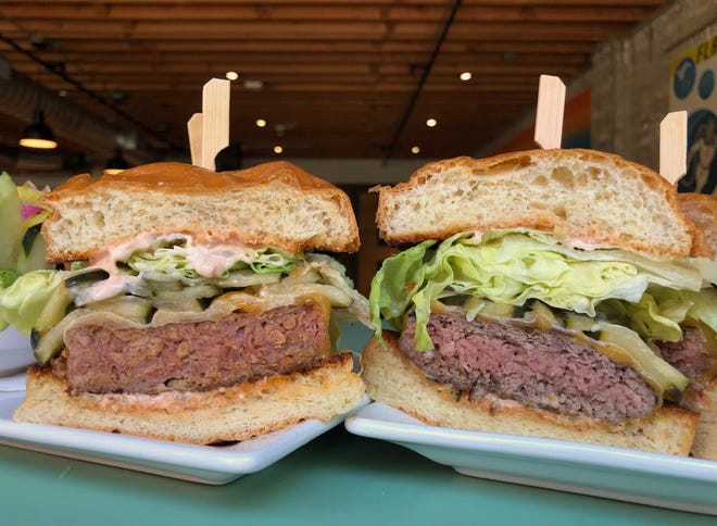 A Beyond Meat burger, left, and a Knee Deep Cattle Co. ground beef burger at Claim 52 Kitchen in Eugene. [Anna Glavash/The Register-Guard]