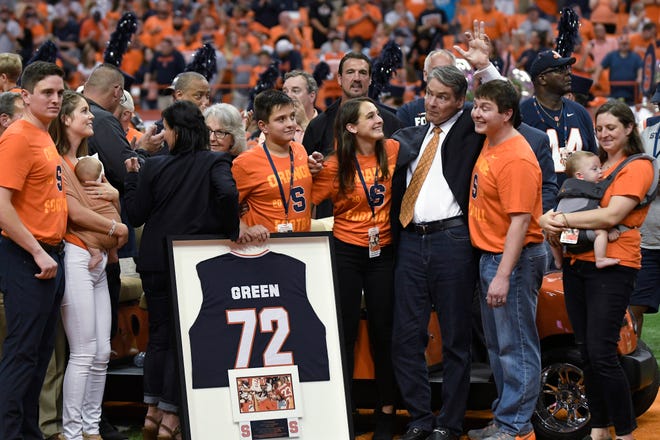 Former Syracuse University and NFL football player Tim Green waves as his number is retired during Saturday's game between Syracuse and Clemson in the Carrier Dome in Syracuse, New York. [Steve Jacobs / Associated Press]