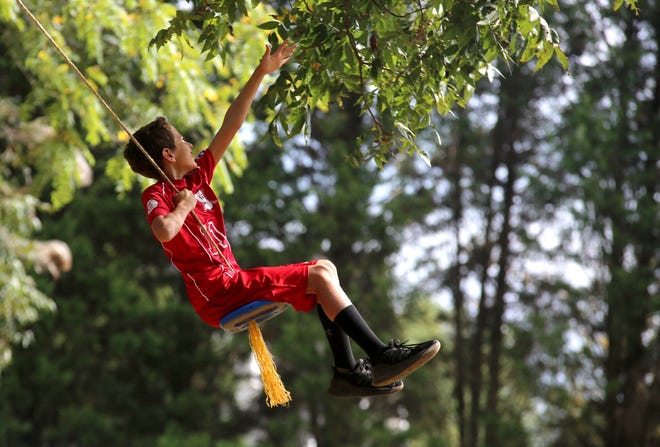 Hunter Hurst, 10, reaches for the trees while swinging at SinRidge Farm’s open house on Saturday. [Brittany Randolph/The Star]
