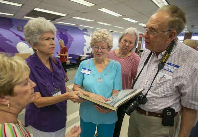 Members of the Gainesville High School class of 1959 talk Sunday with Bob Greene, right, after he found his yearbook during the parting breakfast of their 60th reunion at Gainesville High School. Greene’s yearbook disappeared in the 1960s, and he has no idea how it turned up in the GHS library. [Alan Youngblood/Staff photographer]