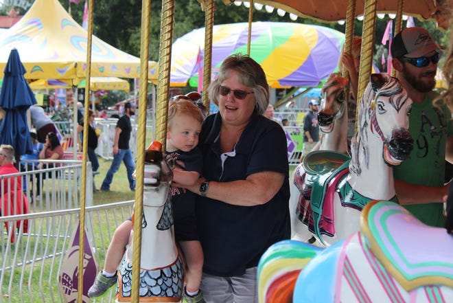 Sturgis resident Debbie Gray enjoyed the merry-go-round Sunday with grandson Coehn Church. They and several thousand people were on hand to enjoy opening day of the 2019 St. Joseph County Grange Fair. [Jef Rietsma/Journal]