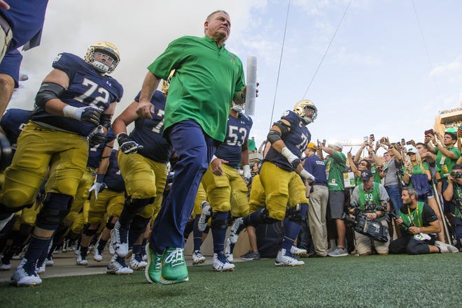 Notre Dame coach Brian Kelly leads his team onto the field at Michigan before a game on Sept. 1, 2018. For the first time ever, the Fighting Irish will visit Sanford Stadium this Saturday. [SOUTH BEND TRIBUNE PHOTO]