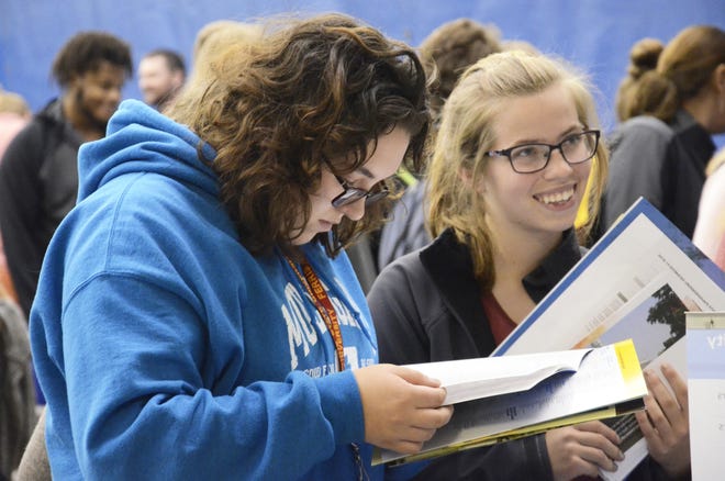 Jamie Lee (left) and Catherine Harke, both juniors at Cheboygan Area High School, gather information about colleges in 2018 during North Central Michigan College's annual College Night. File photo