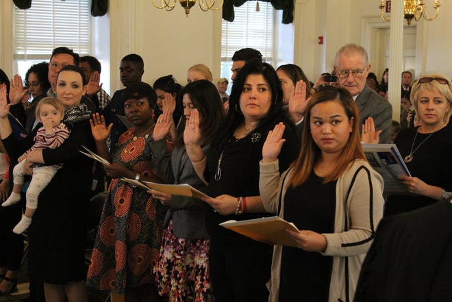 Newly naturalized citizens recite the Oath of Allegiance at the Olde Courthouse in Mount Holly on Thursday. [GIANLUCA D'ELIA/STAFF PHOTOJOURNALIST]