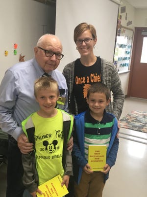 Lu Munger, vice-president of the Cheboygan Kiwanis Club, presented students in third grade teacher Kristin Tebo's class, including Brayden Rauch and Duncan Spies, with dictionaries to be used in class. Photo by Susan Gimble-Crandell.