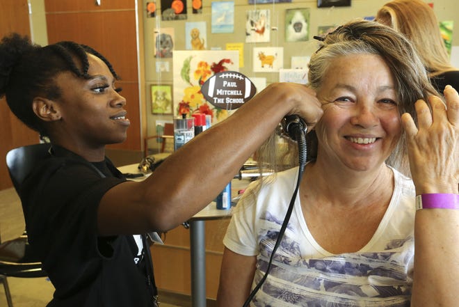 Symone Lucas, left, cuts hair for Brenda Smith as the Lewis and Faye Manderson Cancer Center celebrated survivors and those battling cancer with their Teaming Up To Tackle Cancer day Thursday, Sept. 19, 2019. The Manderson center, which is at the DCH Regional Medical Center, has been treating cancer patients since 1986. [Staff Photo/Gary Cosby Jr.]