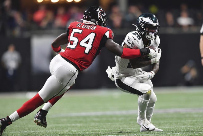 Eagles running back Miles Sanders tries to avoid Falcons linebacker Foye Oluokun during Sunday night's game. [JOHN AMIS / ASSOCIATED PRESS]