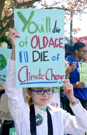 Lucy Garrison, 14, of Miss Hall's School holds a sign during a global climate strike at Park Square Friday, Sept. 20, 2019 in Pittsfield, Mass. A wave of climate change protests swept across the globe Friday, with hundreds of thousands of young people sending a message to leaders headed for a U.N. summit: The warming world can't wait for action. (Gillian Jones/The Berkshire Eagle via AP)