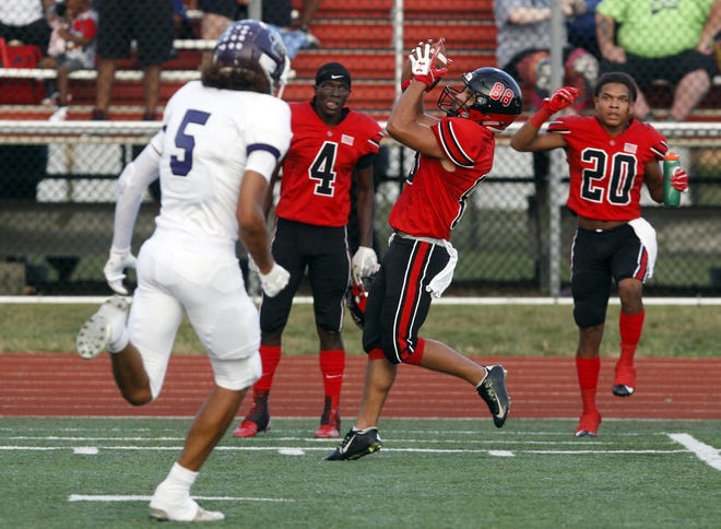 Groveport's Ryan Burke hauls in a reception as teammates Elyjah Aekins (4) and Michael Davis look on from the sideline during a 19-14 victory over against Pickerington Central. [Shane Flanigan/ThisWeek Newspapers]