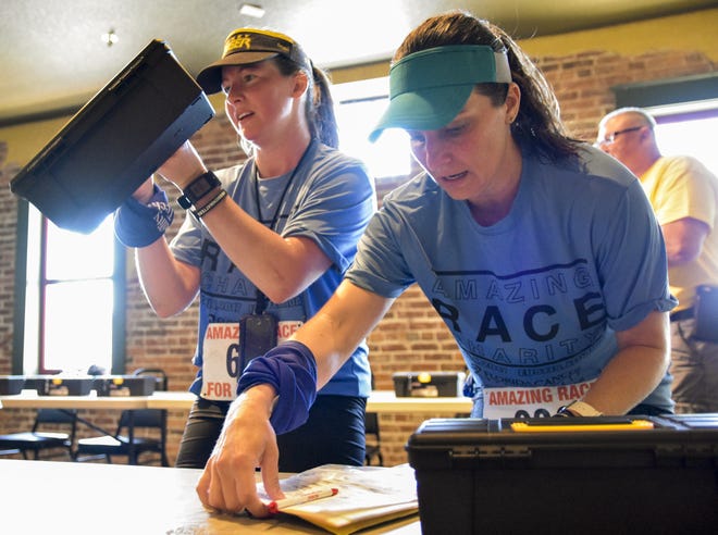 Two women attempt to solve a puzzle during a past Amazing Race for Charity event. [PAUL RYAN / CORRESPONDENT]