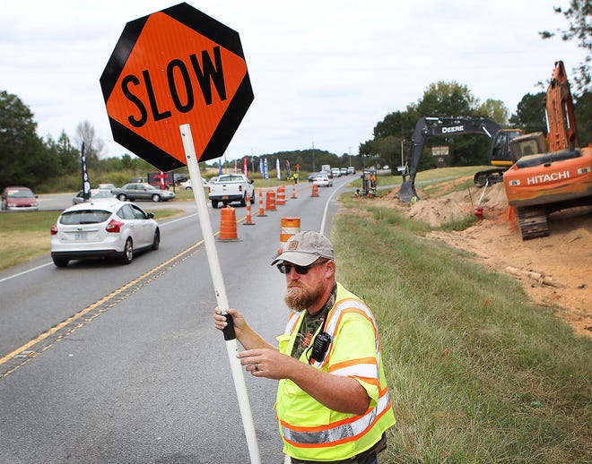 Jordan Lutz works traffic control with a road construction crew on Dallas Cherryville Highway Thursday morning. Lutz recently received a companywide employee of the year award from Labor Finders. [JOHN CLARK/THE GASTON GAZETTE]