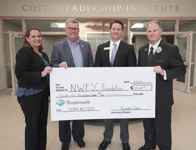 From left are: NWFSC Vice President of College Advancement Cristie Kedroski, NWFSC Foundation Board Chairman C. Jeffery McInnis, President of Trustmark Bank for Okaloosa and Walton Counties and NWFSC Foundation Board Member Jonathan Ochs, and NWFSC President Dr. Devin Stephenson, posing with a pledge of $25,000 towards NWFSC student scholarships on behalf of Trustmark Bank. [CONTRIBUTED PHOTO]