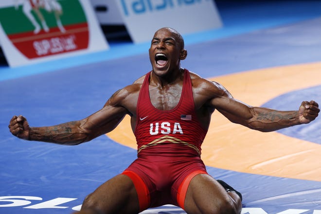 J'Den Cox celebrates his victory over Alireza Karimi of Iran in their gold match of the men's 92kg category during the Wrestling World Championships in Nur-Sultan, Kazakhstan, on Saturday. [Anvar Ilyasov/Associated Press]