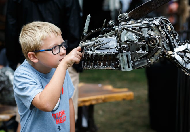 Owen Liberman, 8, inspects the inner workings of a metal sculpture by Joe Peters of Spoon River Bottom Wood and Metal on display during the 31st Annual Edwards Place Fine Art Fair at the Springfield Art Association, Sunday, Sept. 22, 2019, in Springfield. Peters creates sculptures out of various pieces of metal varying from nuts and bolts to lawnmower blades. [Justin L. Fowler/The State Journal-Register]