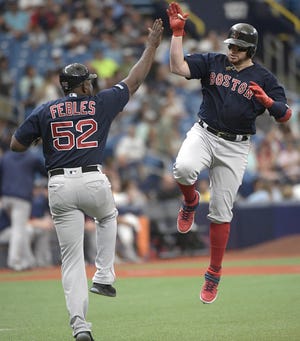 Boston Red Sox catcher Christian Vazquez, right, celebrates with third base coach Carlos Febles (52) while rounding the base after hitting a three-run home run during the first inning Sunday. [AP Photo/Phelan M. Ebenhack]