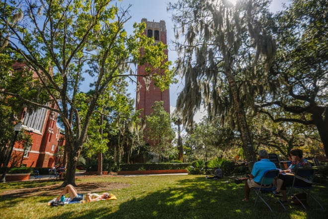 Kelly Dillon, a fourth-year health science major at UF, listens to the music in the grass during the Carillon Studio Recital celebrating the 40th anniversary of the installation of the Century Tower carillon on the UF campus. Dillon said she attended the event because her boyfriend, Ryan Childress, was one of the performers. [Chris Day/Correspondent]