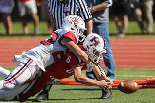 No. 23 Brian Frieh stops Holliston senior quarterback Matt Arvanitis from scoring during the Panthers’ 21-18 win over Barnstable at Holliston High School on Saturday. [PHOTO BY DAN HOLMES/WICKED LOCAL]