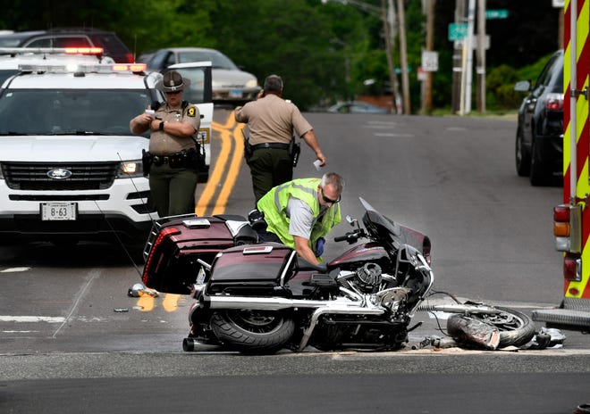A Peoria firefighter spreads absorbent material around the scene of a traffic crash on June 14, 2018, at the intersection of North Knoxville and McClure avenues. [DAVID ZALAZNIK/JOURNAL STAR]