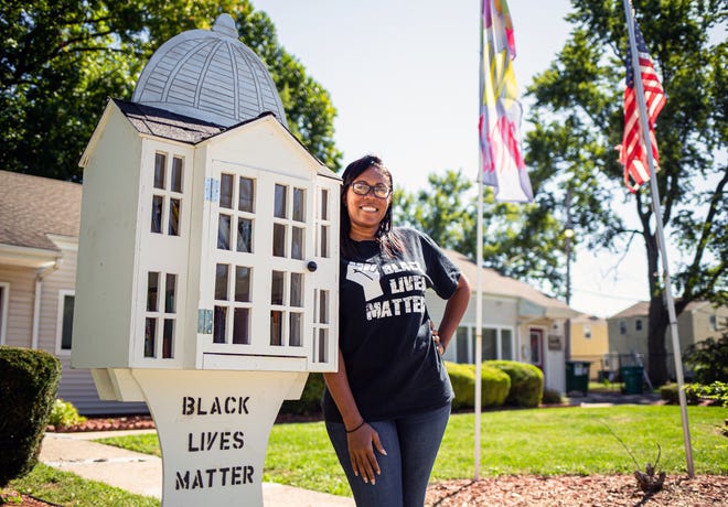 Sunshine Clemons of Black Lives Matter Springfield with the group's new "free little library" dedicated to black authors and subject matter outside the rental office for Poplar Place Apartments Monday, Sept. 23, 2019, in Springfield. [Justin L. Fowler/The State Journal-Register]