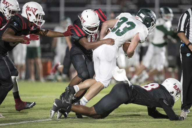 South Walton's Tyler Mitchum (33) tries to break free of a tackle during Thursday's game against Bay at Tommy Oliver Stadium. [JOSHUA BOUCHER/THE NEWS HERALD]