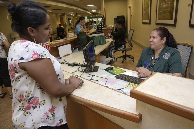 Auxiliary president Norma Gonzalez-Knight assists a woman in the front lobby at the Leesburg Regional Medical Center. [Cindy Sharp/Correspondent]