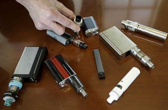 In this 2018 file photo, a high school principal displays vaping devices that were confiscated from students in such places as restrooms or hallways. The U.S. surgeon general says swift action is needed to prevent millions of teens and adolescents from becoming hooked on Juul and other high-nicotine electronic cigarettes. [AP Photo | Steve Senne]
