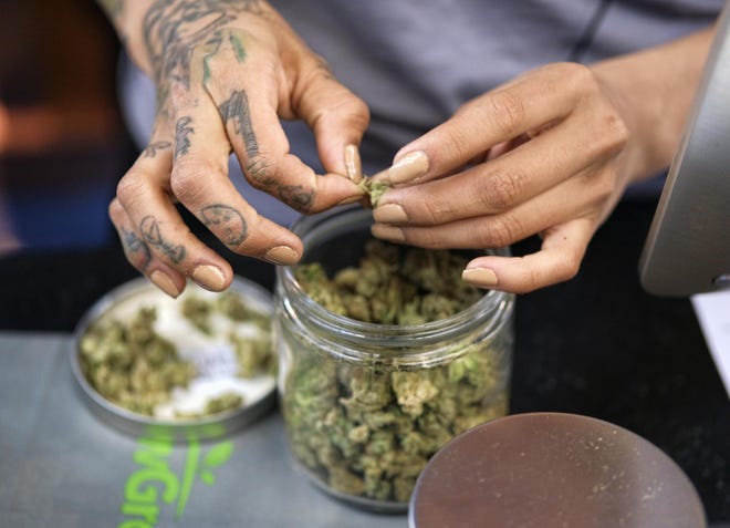 In this April 15, 2017, file photo a budtender weighs out marijuana for a customers at ShowGrow, a medical marijuana dispensary in downtown Los Angeles. (AP Photo/Richard Vogel, File)
