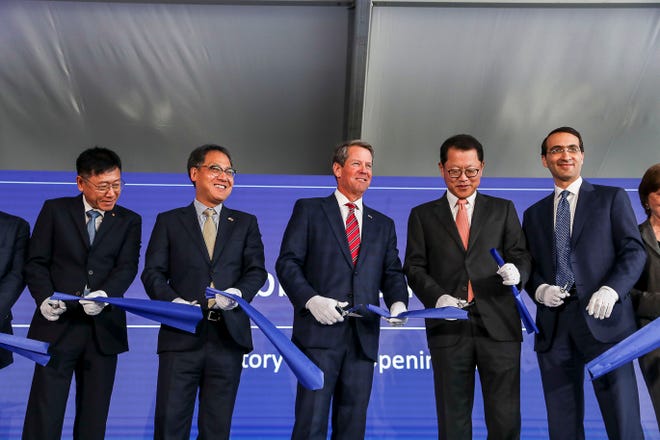 Gov. Brian Kemp, center, participates in a ribbon cutting with Hanwha Q Cells CEO Charles Kim, second from right, and Assistant Secretary of Commerce for Enforcement and Compliance Jeffery Kessler, right, during the grand opening of a Hanwha Q Cells solar manufacturing facility in Dalton, Ga., Friday, Sept. 20, 2019. The plant started production earlier this year. It is the largest solar manufacturing plant in the Western Hemisphere. (Alyssa Pointer/Atlanta Journal-Constitution via AP)