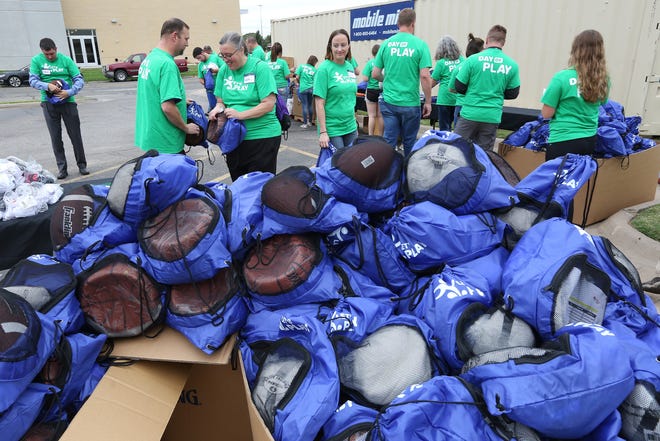 More than 780 sports bags filled with a T-shirt, shorts and an athletic ball were put together by volunteers during the "Day of Play" event Thursday afternoon at the YMCA. [Sandra J. Milburn/HutchNews]