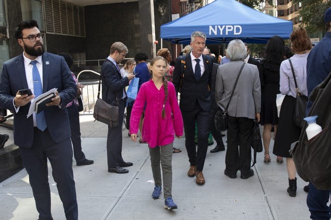 Environmental activist Greta Thunberg, center, of Sweden, walks with an entourage after passing a security checkpoint while appearing at the United Nations, Monday, Sept. 23, 2019 in New York.