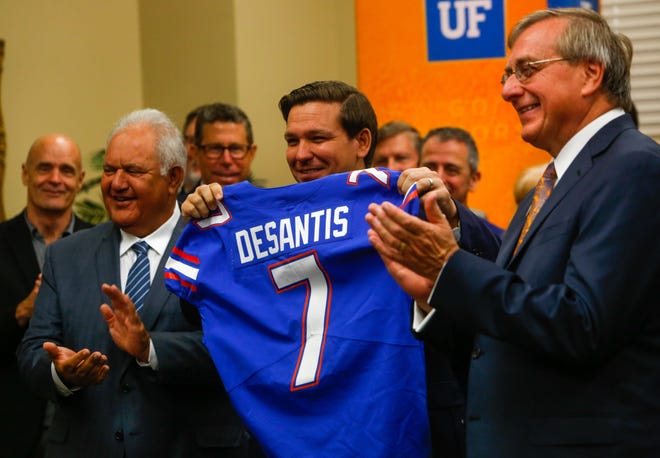 Gov. Ron DeSantis is given an honorary football jersey after it was announced that the University of Florida reached No. 7 among top public universities in the U.S. News & World Report rankings. [Gainesville Sun/ File]
