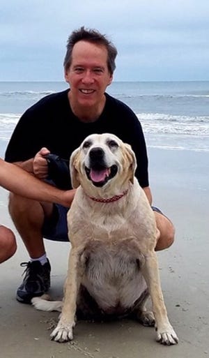 Author Gary Williams, right, with his Labrador retriever Guen will be at the Hang 20 Pups and Sups event Saturday. [Contributed photo]