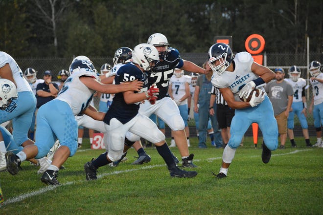 Sault High's Daylan Lujan (59) and Matt Edington (75) pursue Petoskey's Jarrin Kelly (2) during last week's football game. The Blue Devils are at home again this Saturday, when they will host Ogemaw Heights. [Rob Roos/Sault News]