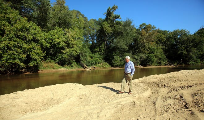 Don Melton walks along the natural sandbar that can be used as a beach in a future greenway trail in Lawndale. [Brittany Randolph/The Star]