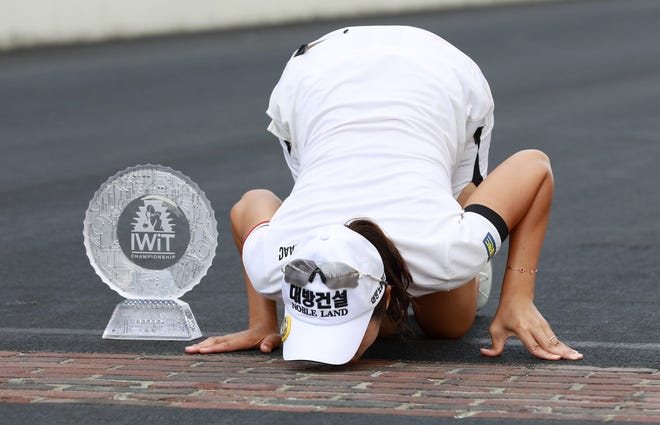 Goler Mi Jung Hur follows auto racing tradition Sunday by kissing the bricks at Indianapolis Motor Speedway after winning the Indy Women in Tech Championship. [R Brent Smith/The Associated Press]