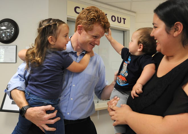U.S. Rep. Joseph P. Kennedy III holds 3-year-old Isabella Rodrigues as her 9-month-old brother Nathaniel Rodrigues reaches for a strand of the representative's hair. Nathaniel Rodrigues is held by his mother, Jacqueline Feregrino-Rodrigues. The children's father is Daniel Rodrigues, associate director of substance use disorder services at Duffy Health Center. [Merrily Cassidy/Cape Cod Times]