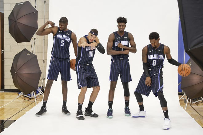 Orlando Magic players Mo Bamba (5), from left, Aaron Gordon (00), Jonathan Isaac and Terrence Ross (31) have some fun posing for photos during the NBA basketball team's media day Monday in Orlando. [JOHN RAOUX/THE ASSOCIATED PRESS]