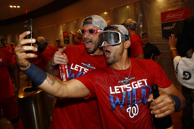 Washington Nationals starting pitcher Max Scherzer, left, and Gerardo Parra celebrate after the second game of a doubleheader against the Philadelphia Phillies on Sept. 24 in Washington. Washington won 6-5 and clinched a wild card berth. the Nationals host the Milwaukee Brewers on Tuesday in the National League wild card game. [PATRICK SEMANSKY/THE ASSOCIATED PRESS]