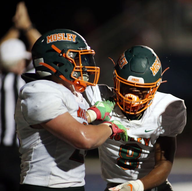 Mosley players celebrate after blocking a punt for a safety at the end of the first half during the Fort Walton Beach vs Mosley football game at Steve Riggs Stadium. [MICHAEL SNYDER/DAILY NEWS].