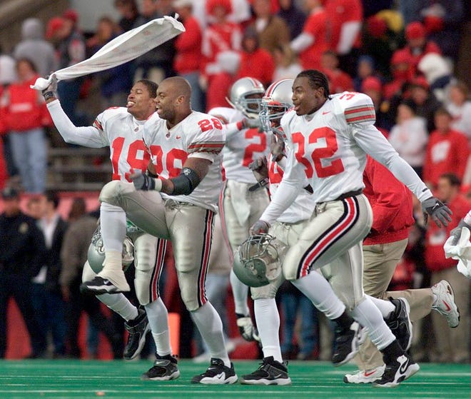 B.J. Barre (19), Jonathan Wells (28) and Marco Cooper (32) lead Ohio State players onto the field at Camp Randall Stadium to celebrate on the Wisconsin logo after a win on Oct. 7, 2000. [File photo]