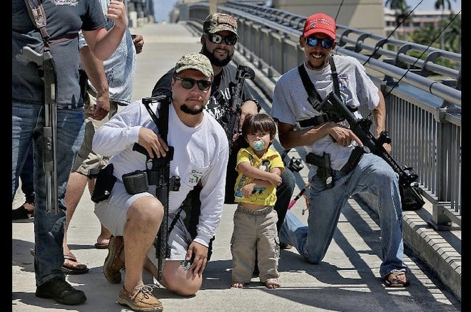 Lukas Garcia (from left), Ruben Espinosa, Slade Espinosa, 2, and Michael Taylor, members of Florida Carry, a nonprofit organization that promotes gun rights in Florida, hold an assembly at the Royal Park Bridge in March. [TIM STEPIEN/palmbeachpost.com].