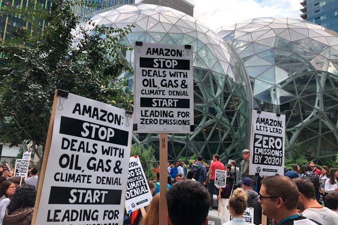 Amazon workers protest in front of the company's landmark Spheres in Seattle on Sept. 20 as part of the climate strike. Environmentally focused employees there and at Microsoft have been pushing their employers to cut ties with the fossil fuel industry, but tech executives are continuing to pursue the lucrative contracts. [Elaine Thompson/Associated Press]